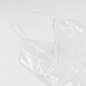 Detailansicht aus weißer Spitze mit Pailletten bei einem sexy Party-Trägerkleid