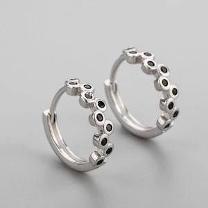 Detailed view of silver wavy hoop earrings featuring embedded black cubic zirconia stones