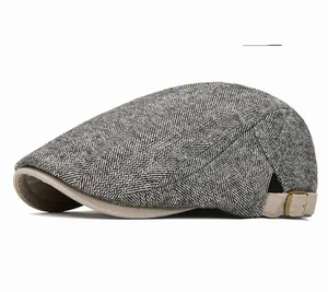 Detail of light gray chevron pattern newsboy cap with adjustable metal side buckle