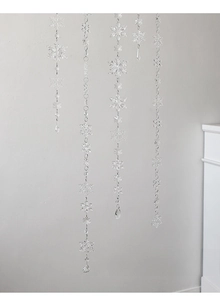 Hanging acrylic snowflake ornaments for Christmas tree decor in a cozy indoor setting