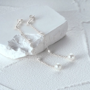 Detail of s925 silver long tassel earrings with white pearls and sparkling cubic zirconia
