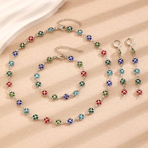 Macro shot of silver clover jewelry set with red blue and green enamel elements