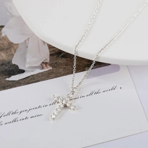 Macro shot of silver plated cross pendant necklace with sparkling cubic zirconia