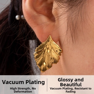 Détail macro de boucles d'oreilles feuille de ginkgo dorée avec placage sous vide