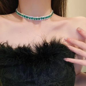 Nahaufnahme der eleganten Halskette mit smaragdgrünen Edelsteinen an einem Model