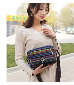Detail shot of ethnic canvas crossbody bag with colorful stripes and adjustable strap