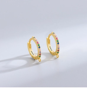 Macro detail of gold-plated S925 sterling silver hoop earrings with rainbow gemstones