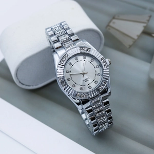 Gros plan d'une montre à quartz argentée avec lunette en strass et bracelet à maillons