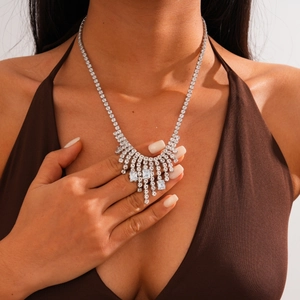Detail of silver tassel necklace with square zircons worn by a model in close-up shot