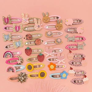 Detailed flat lay of 28 assorted colorful cartoon animal and fruit clips for girls