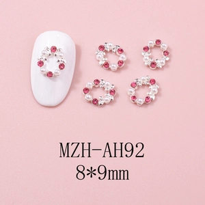 Détail du bijou d'ongle couronne de Noël 8x9mm avec strass roses et perles blanches