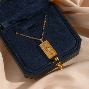 Golden tarot sun pendant necklace with three crystals on a luxury velvet display