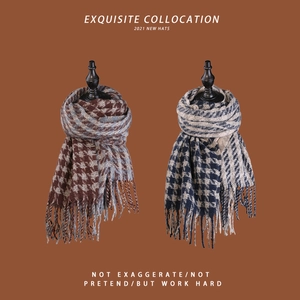 Detail of winter houndstooth knit scarves with tassels in blue and red-brown tones