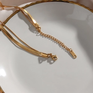 Three-layer 18K gold plated stainless steel snake bone chain necklace on jewelry tray