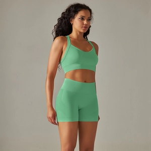 Detailed texture of seamless green yoga set showing high-waist shorts and sports bra