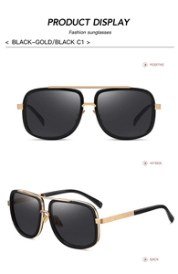 Detail view of fashion square sunglasses with gold and black metal frame and dark lenses