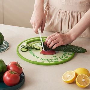 Dual-sided round plastic cutting board with watermelon design and green handle for fruit