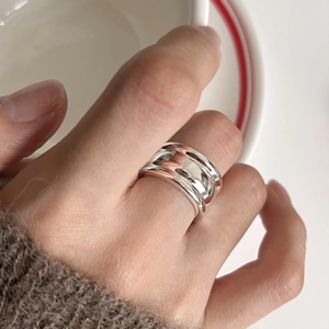 Macro detail of a 925 sterling silver triple-layered wide band ring on model finger