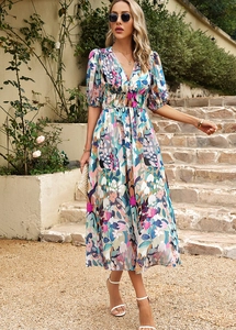 Détail du col en V profond et de la taille haute sur une robe mi-longue à fleurs