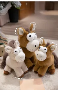 Détail de trois peluches de chevaux drôles assises sur une couverture blanche douce