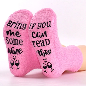 Pink coral fleece sleep socks with non-slip 'Bring me some wine' lettering on soles