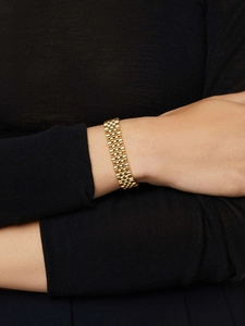 Close-up of golden stainless steel jubilee style watch strap on a model wrist