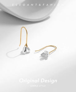 Detailed macro view of S925 silver magnolia bud earrings with long gold ear hooks
