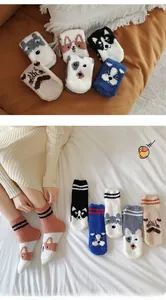 Close-up of thick coral fleece socks with cute cartoon dog patterns for winter warmth