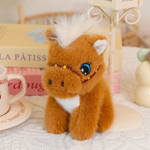 Detail of plush brown horse keychain with blue eyes and silver sparkle mane decoration