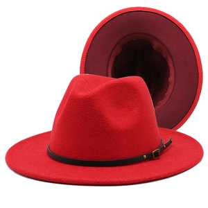 Detail of red wool fedora hat featuring a black leather belt and gold buckle accent