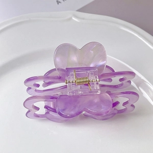Close-up of purple heart-shaped acetate hair claw clip with rhinestone details