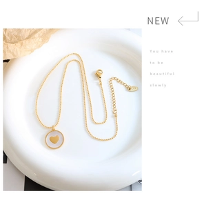Detail of gold heart pendant necklace with K18 tag and adjustable extension chain