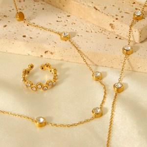 Detailed view of 18K gold plated necklace and ring with zircon on silk and stone