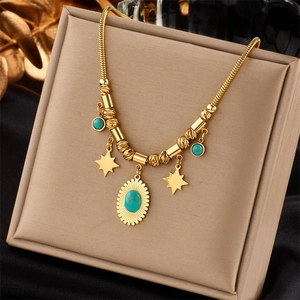 Detail of gold star necklace with turquoise pendant on a beige jewelry display stand