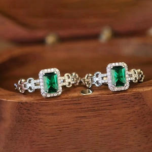Dettaglio macro di anelli con gemma verde taglio smeraldo e fascia in argento traforato