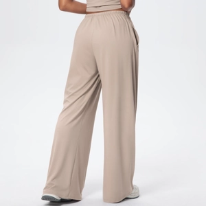 Detail view of the drawstring elastic waistband and side pocket on khaki wide leg pants