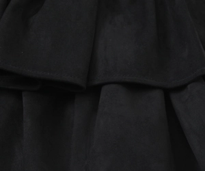 Gros plan sur le tissu en daim noir et les détails de volants d'une robe courte
