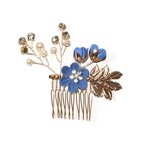 Detail of bridal hair comb with blue fabric flowers and golden rhinestone leaves