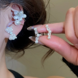 Vue détaillée de clips d'oreilles en perles et zircons en forme de nœud et de fleur