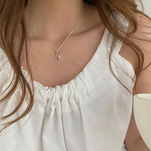 Detail of 925 sterling silver necklace with lock pendant on model's neck