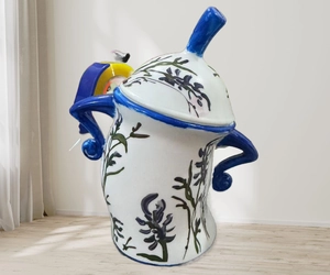 Detail of white ceramic canister with hand-painted blue floral patterns and curved lid