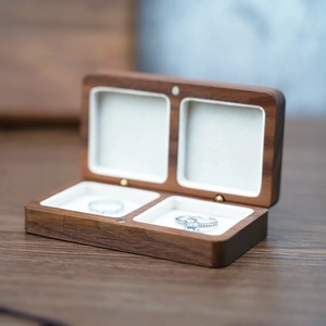 Detail of walnut wood double ring box showing the natural grain and white velvet lining