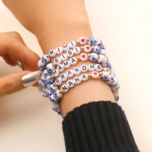 Primo piano di braccialetti in ceramica a strati con scritte come Gigi e Mama