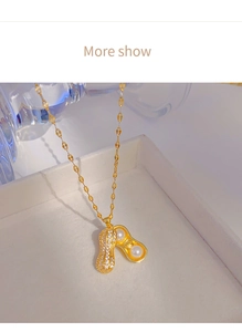 Macro d'un pendentif cacahuète ouvrable en or avec perles et zircons sur fond blanc