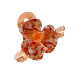 Elegant orange acetate flower hair claw with marble texture for versatile hair styling