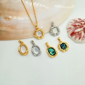 Close-up of 18K gold plated oval pendants with mother of pearl and abalone shell inlays