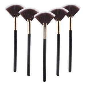 Detailed view of five professional fan-shaped makeup brushes with black and gold handles
