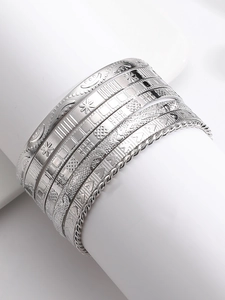 Macro detail of silver vintage bangles set with intricate floral and geometric engravings