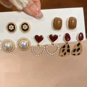 Detail eines Vintage-Ohrring-Sets mit Perlen, Herzmotiven und Leopardenmuster