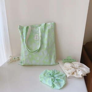 Detail of light green puckered cotton tote bag with matching hair accessories and clips